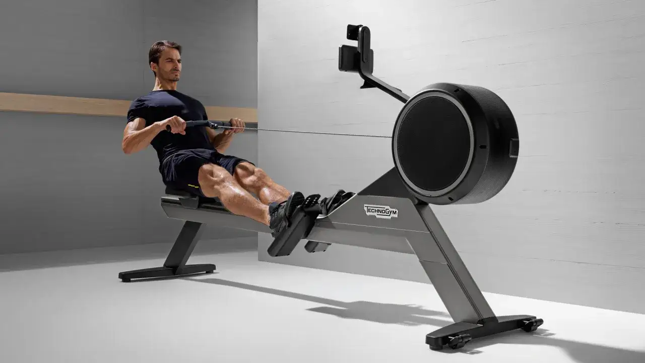 Un homme s'entraîne sur un rameur, sollicitant ses muscles pour un entraînement complet.